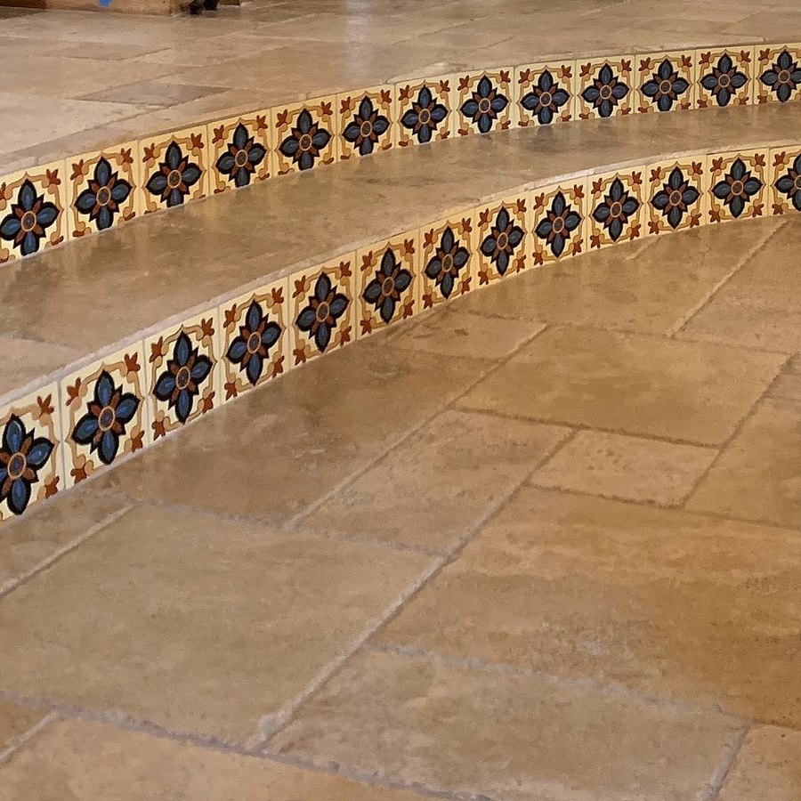 Close-up of patterned tile risers on travertine steps
