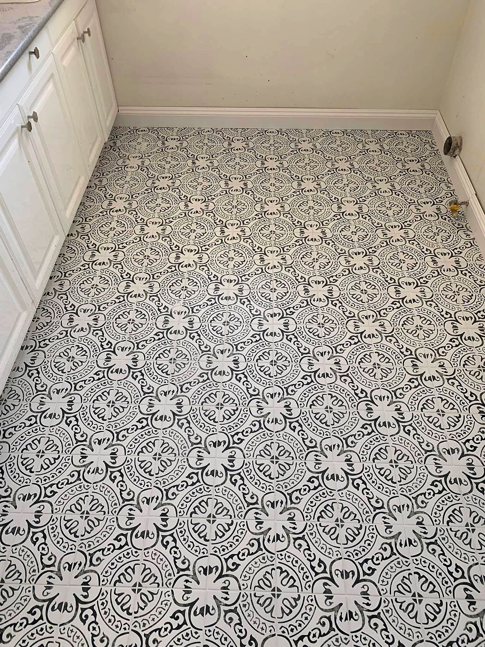 Black and white patterned floor tile in a small room