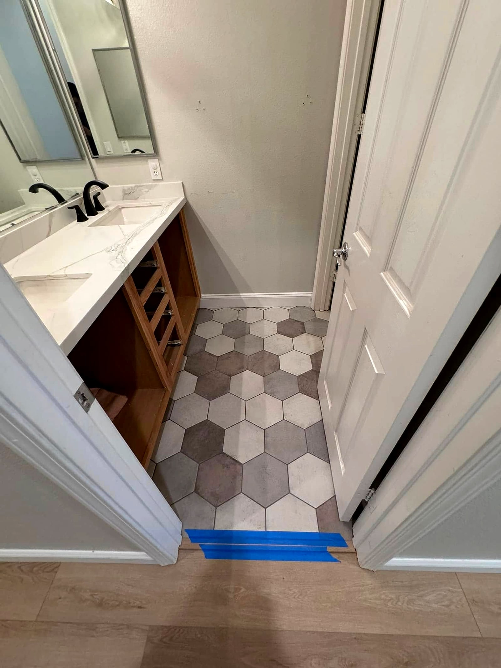 Hexagon tile running into a bathroom vanity area