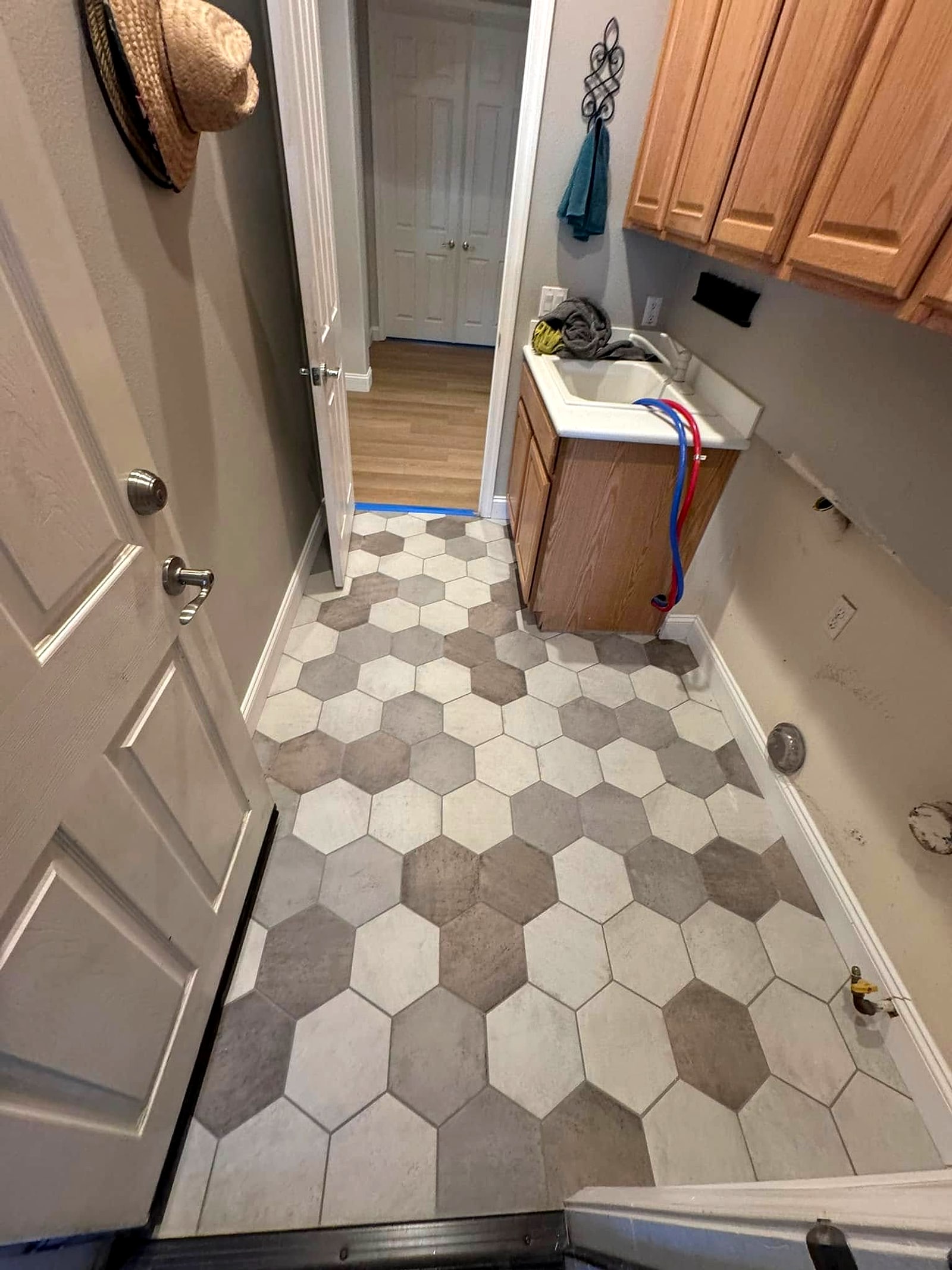 Laundry room with hexagon floor tile