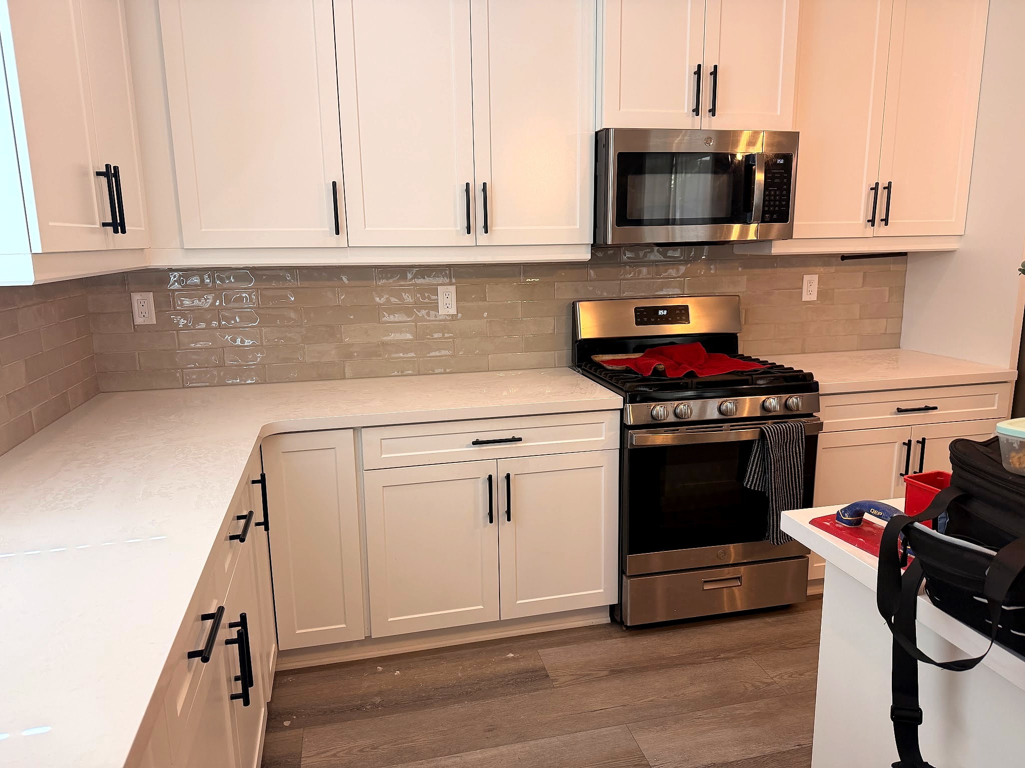 The customer’s own photo of a white kitchen with a tile backsplash