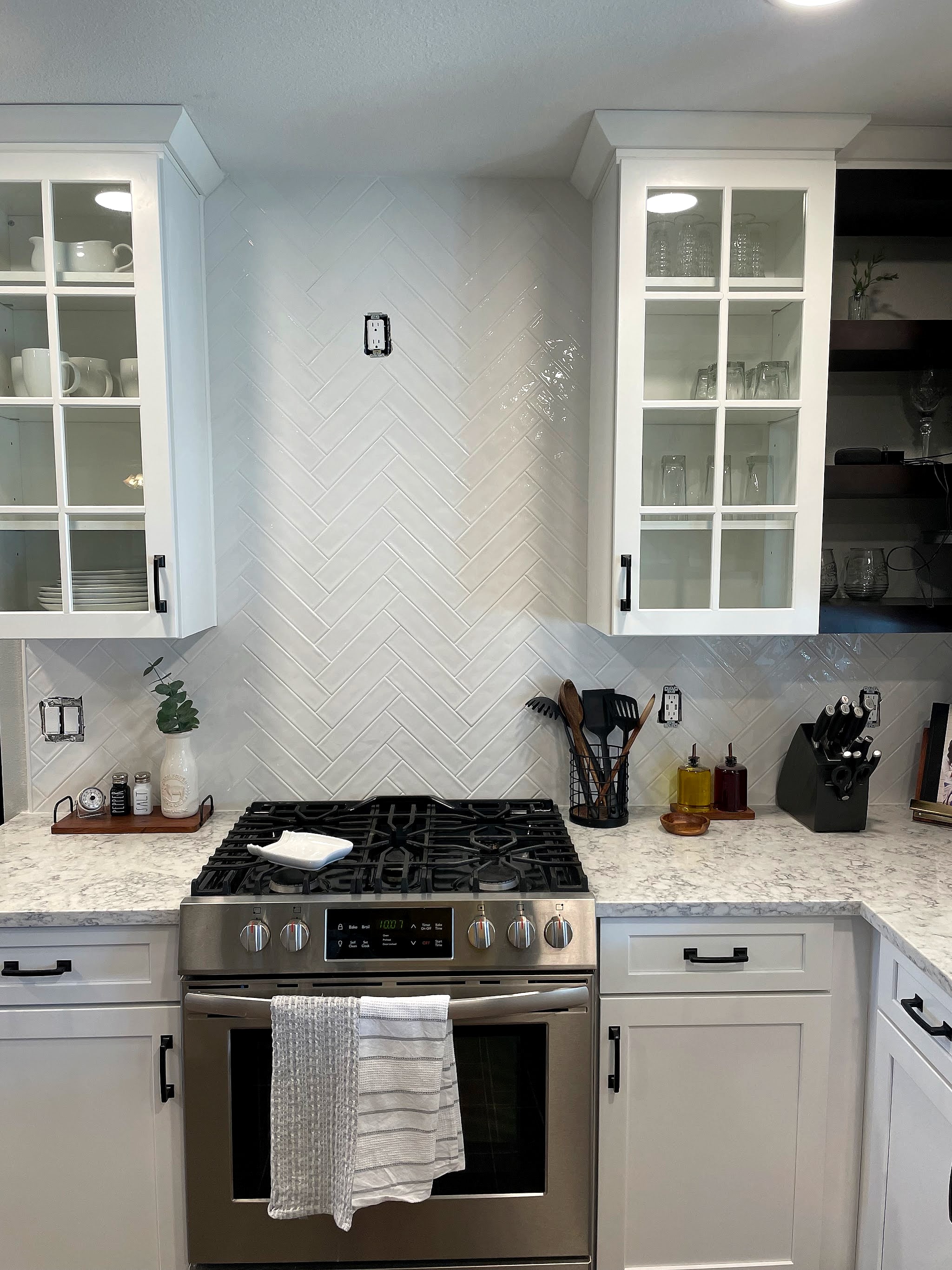 White herringbone backsplash behind a kitchen range